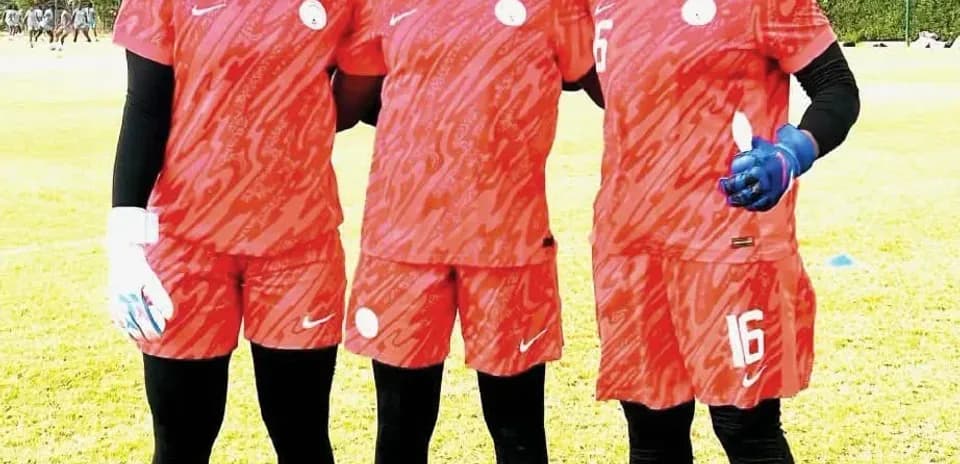 Tres jugadoras de fútbol posando en uniforme rojo