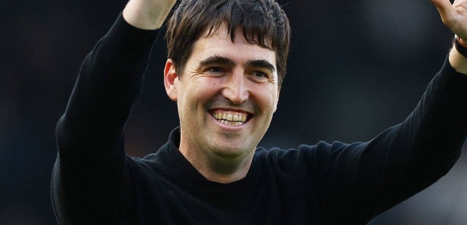Entrenador sonriendo y saludando al público