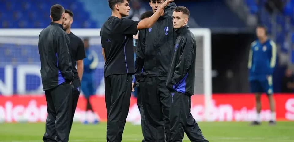 Jugadores de pie conversando en el campo de entrenamiento