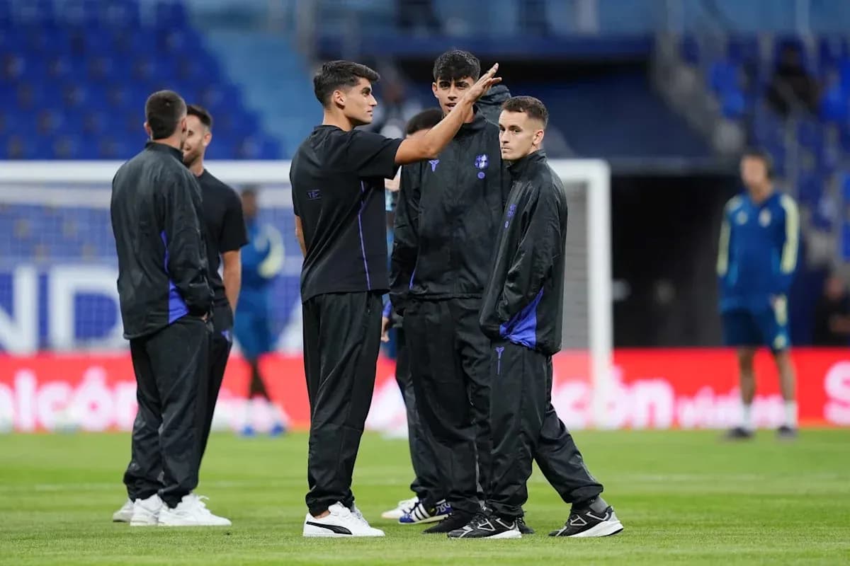 Jugadores de pie conversando en el campo de entrenamiento