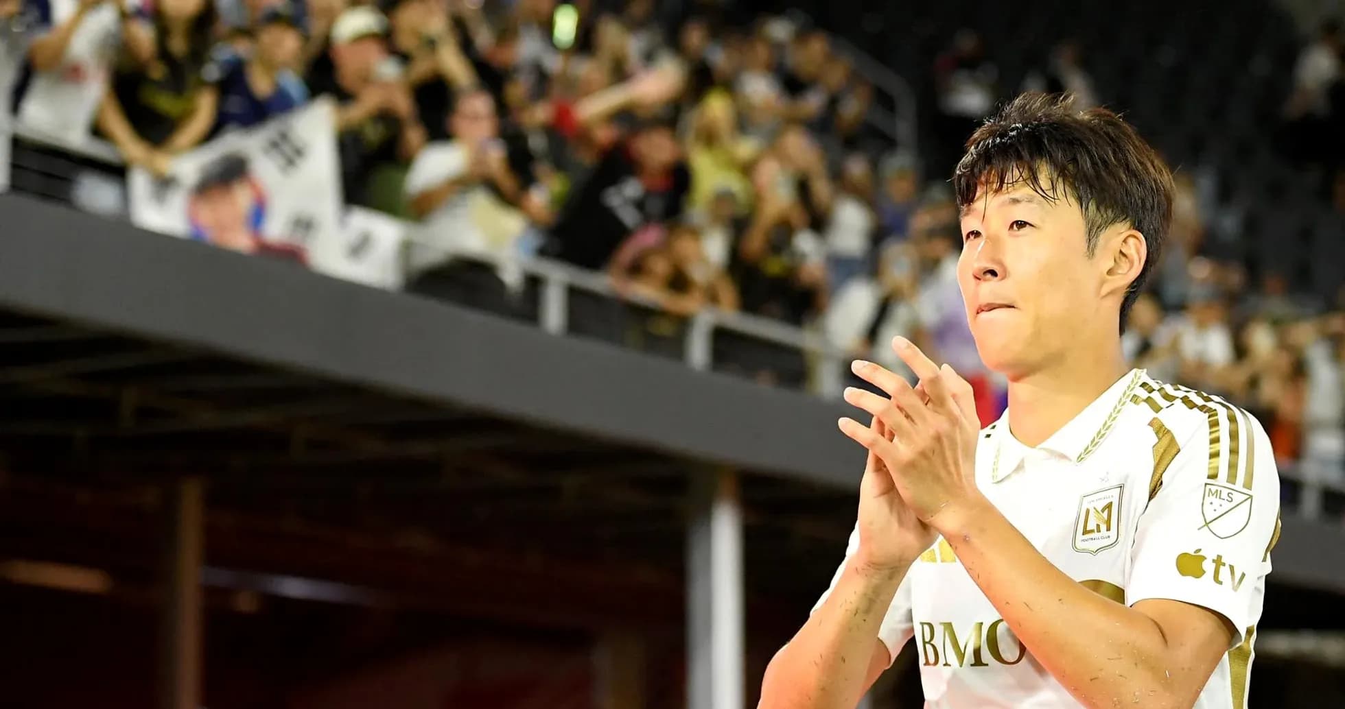 Jugador aplaudiendo frente a aficionados en el estadio