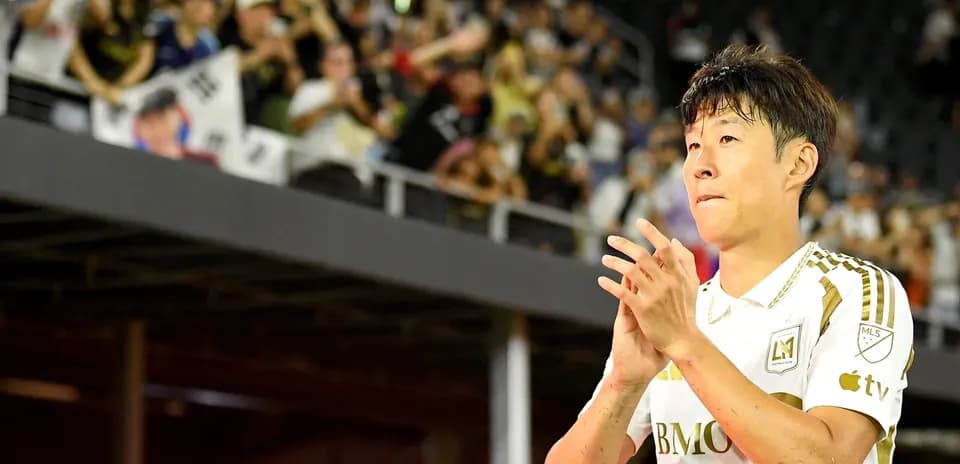 Jugador aplaudiendo frente a aficionados en el estadio