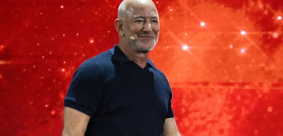 Hombre con micrófono en escenario con fondo rojo