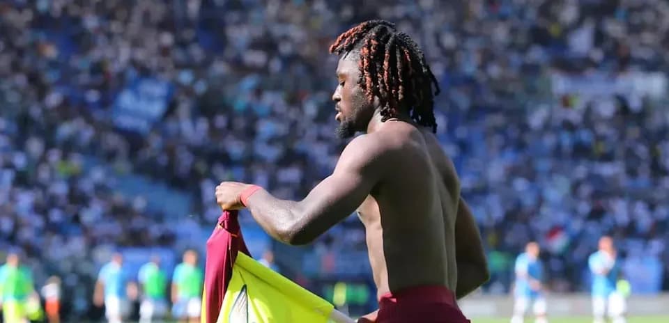 Jugador sosteniendo camiseta en el campo de fútbol