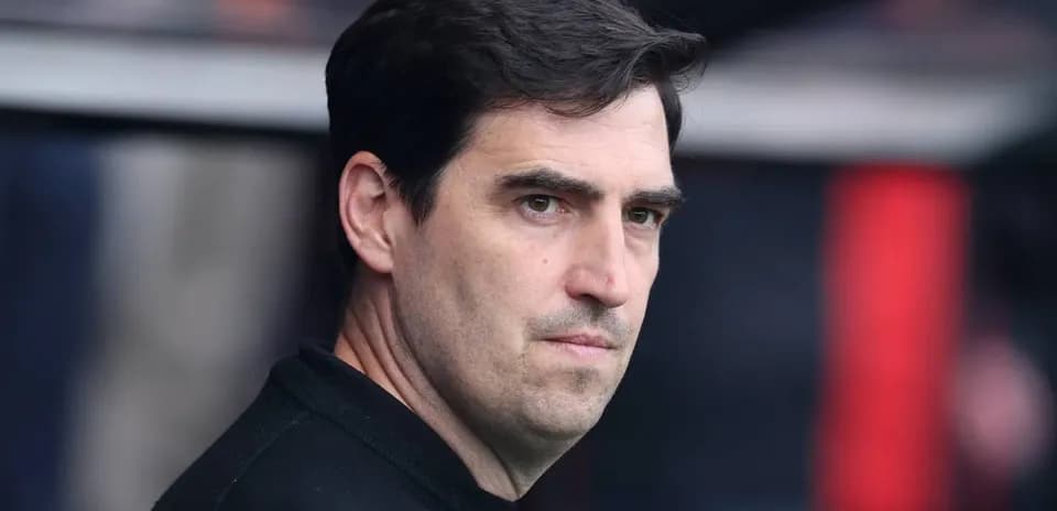Entrenador observando el partido desde el banquillo