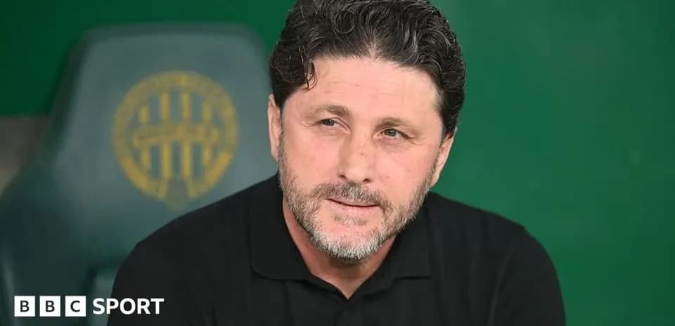 Entrenador sentado en banco de suplentes durante partido