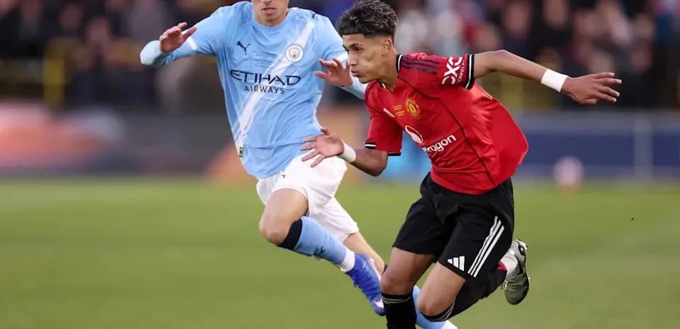 Jugador de Manchester United driblando a rival de Manchester City