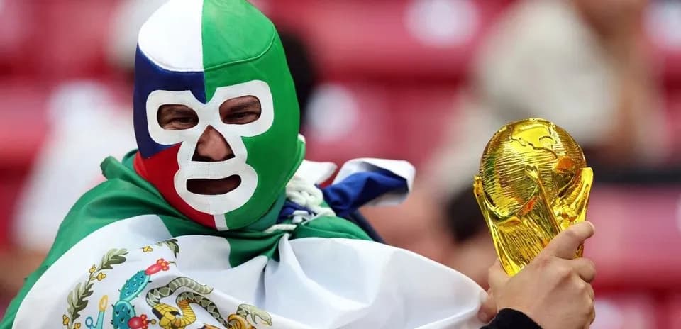 Afanático con máscara sosteniendo la Copa del Mundo
