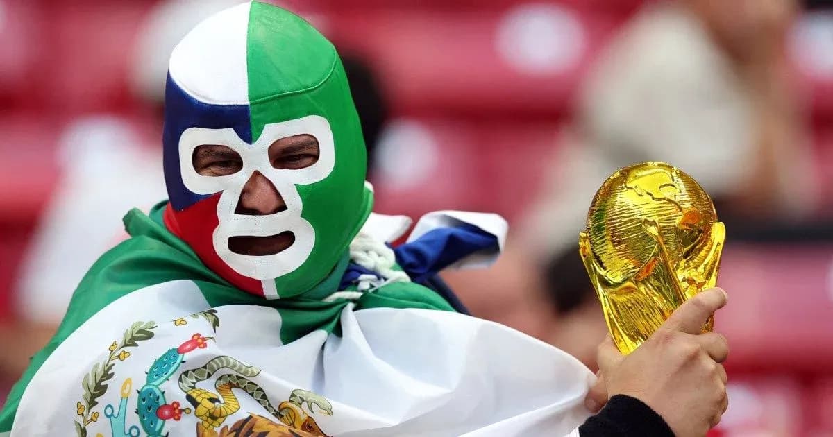 Afanático con máscara sosteniendo la Copa del Mundo