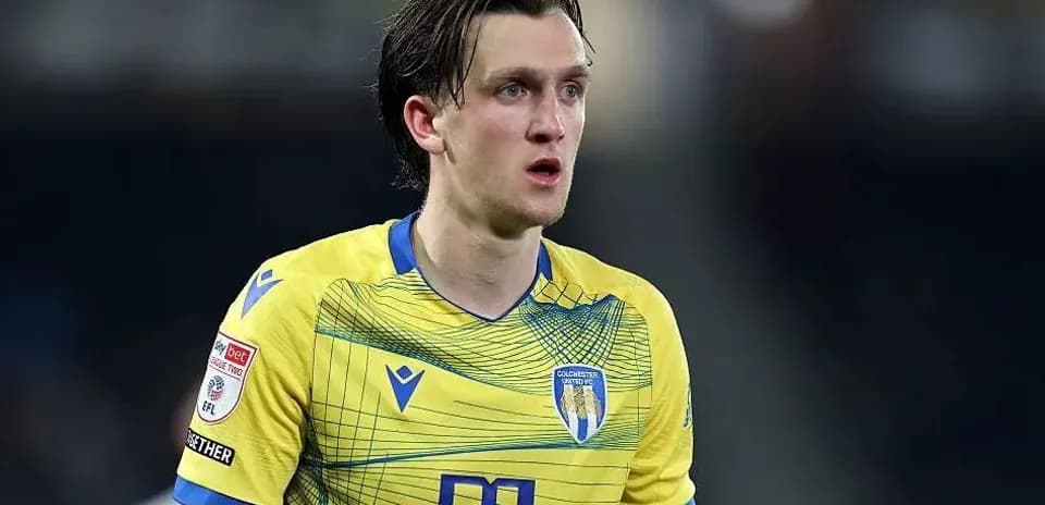Jugador de Colchester United en camiseta amarilla durante partido