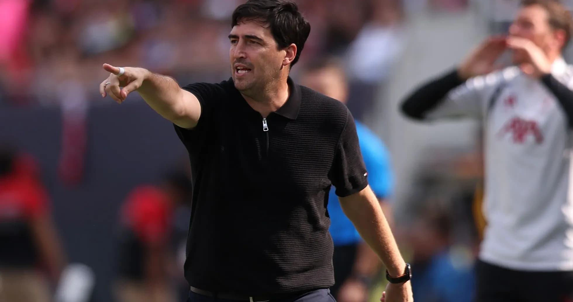 Entrenador dirigiendo instrucciones desde la línea de banda