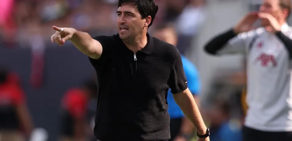 Entrenador dirigiendo instrucciones desde la línea de banda
