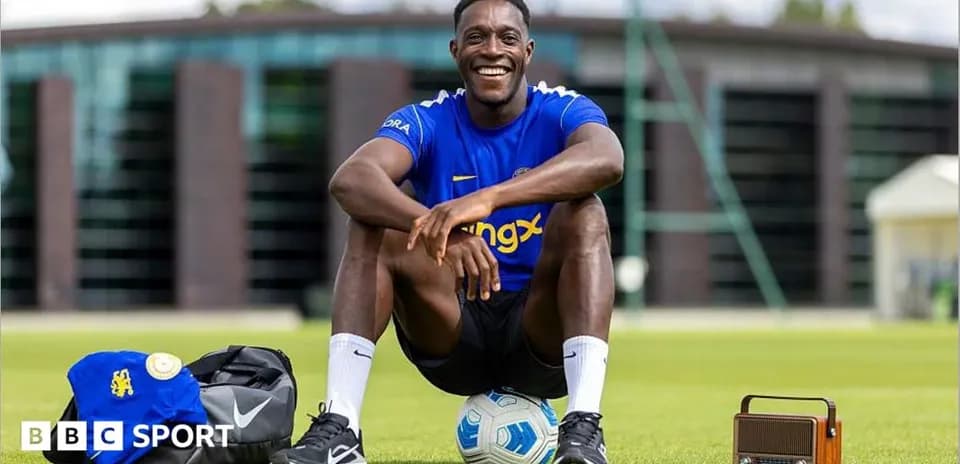 Jugador sentado en campo de entrenamiento con balón