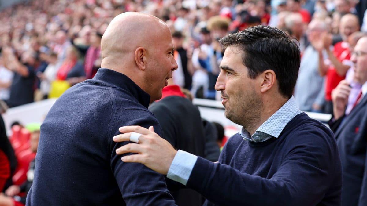 Dos entrenadores saludándose en el estadio