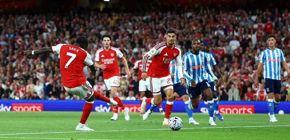 Saka disparando a portería durante un partido