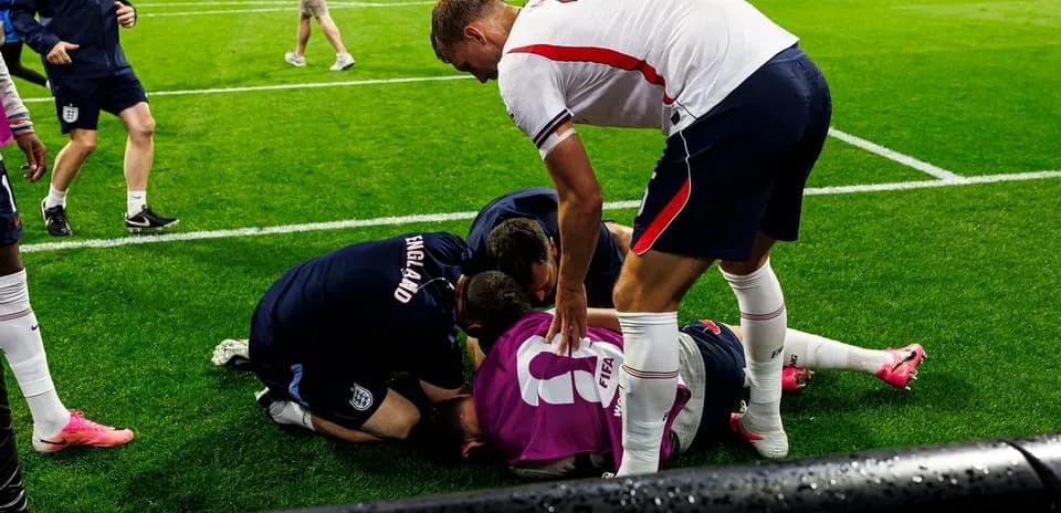 Jugadores de Inglaterra atendiendo a un compañero caído