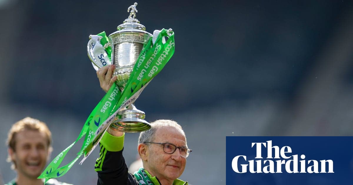 Entrenador levantando trofeo con cintas verdes