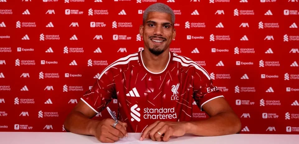 Jugador firmando contrato con Liverpool en conferencia