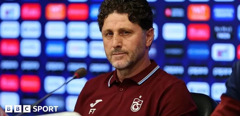 Entrenador en conferencia de prensa con fondo de patrocinadores