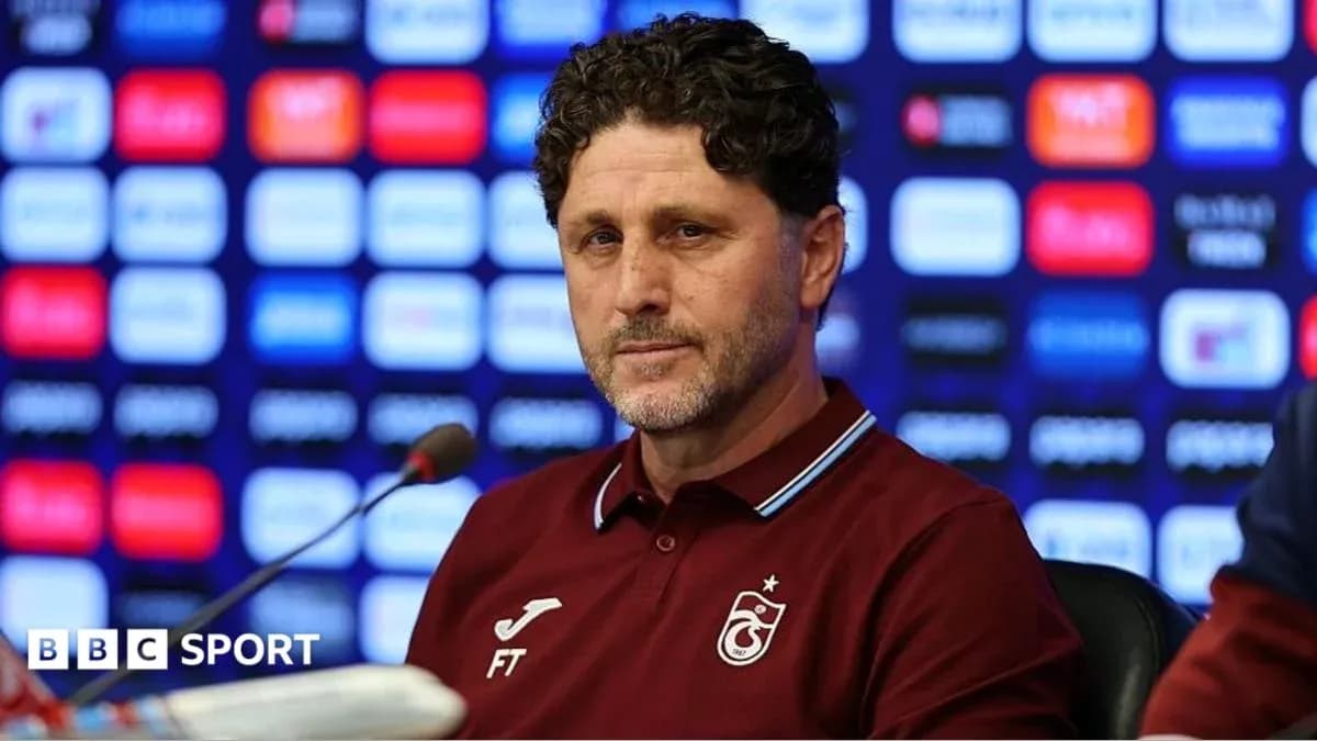 Entrenador en conferencia de prensa con fondo de patrocinadores