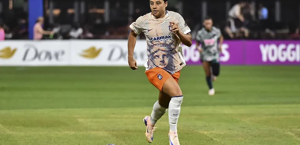 Jugadora corriendo con el balón durante el partido
