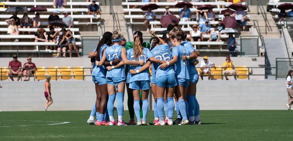 Jugadoras en círculo antes del inicio del partido
