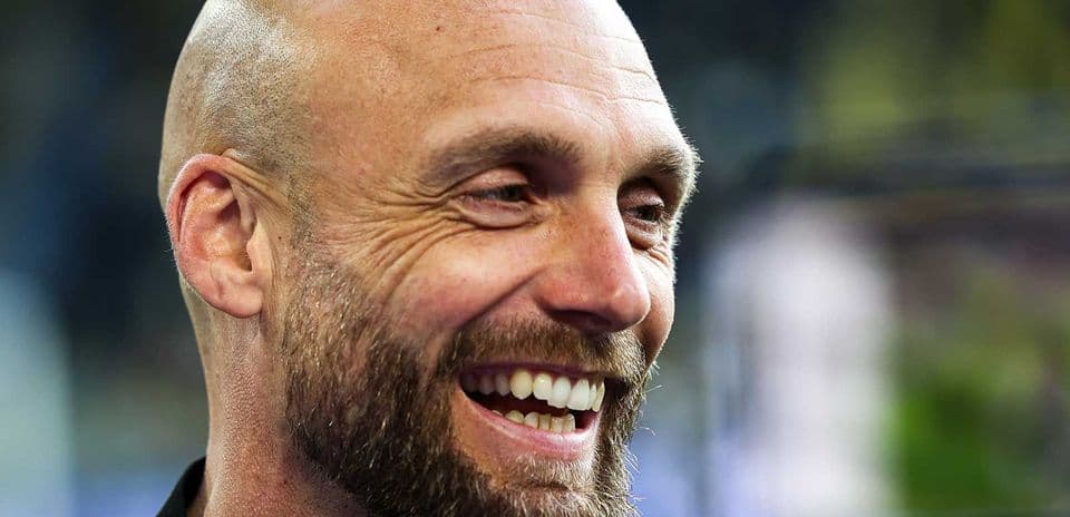 Entrenador sonriendo durante una entrevista