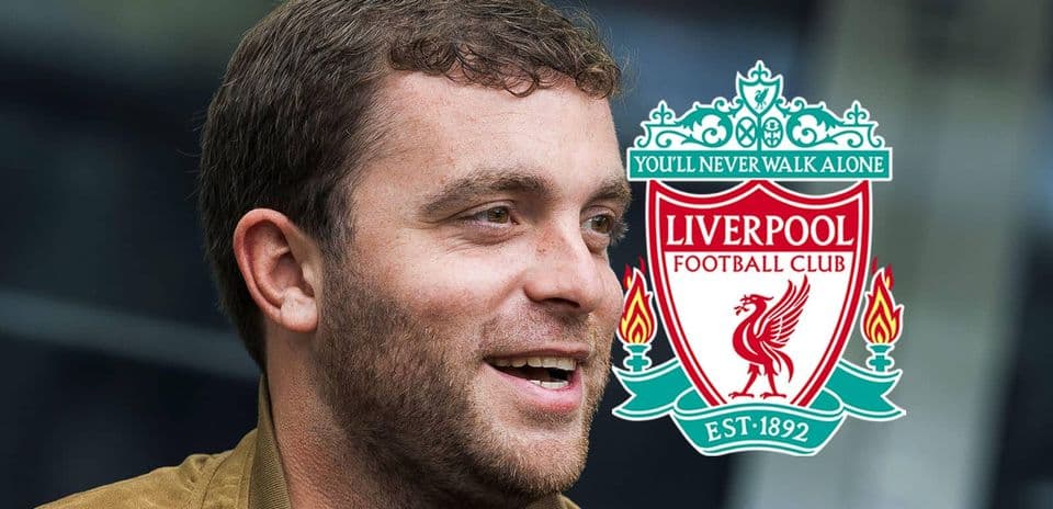 Persona sonriendo junto al escudo de Liverpool FC