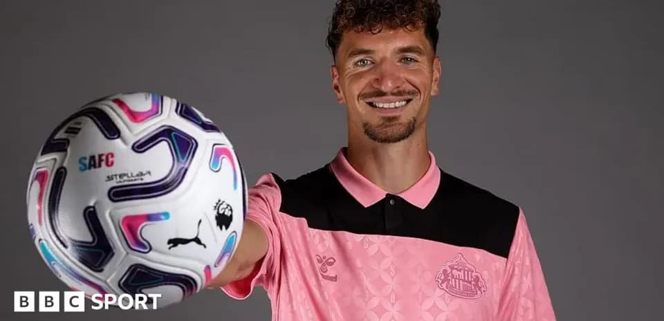 Jugador sosteniendo un balón de fútbol en estudio
