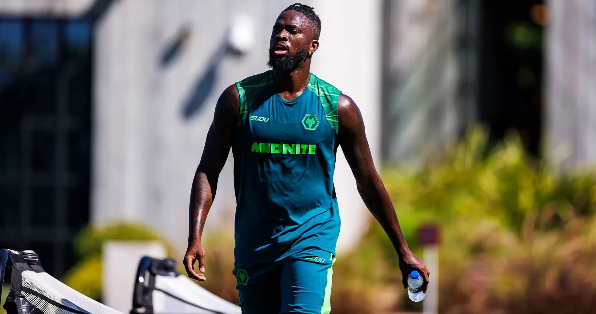 Jugador caminando con botella de agua durante entrenamiento