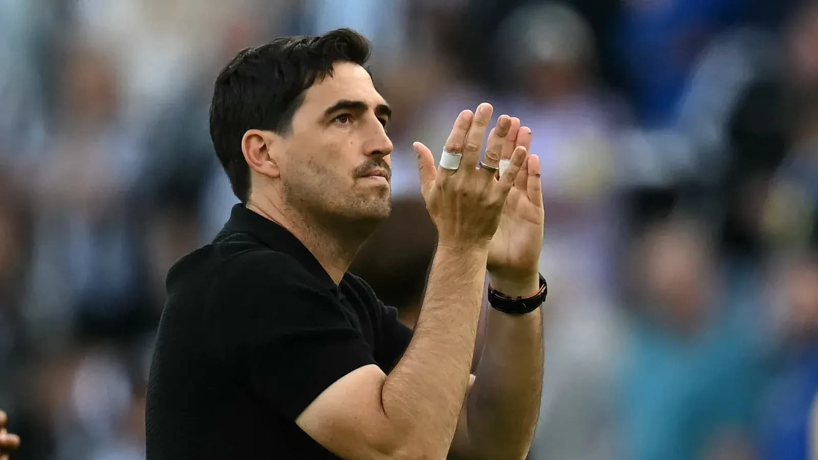 Entrenador aplaudiendo a la afición en el estadio