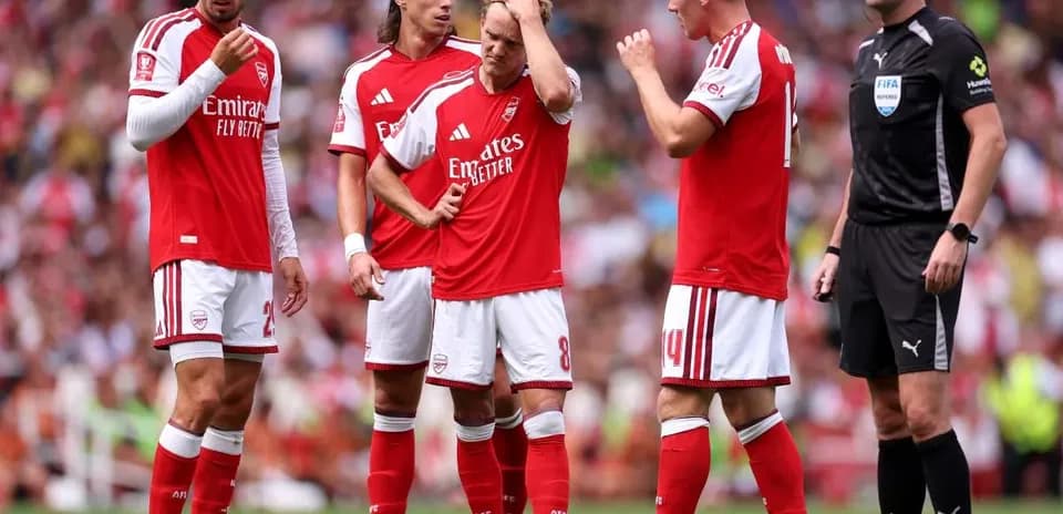 Jugadores de Arsenal discutiendo con el árbitro