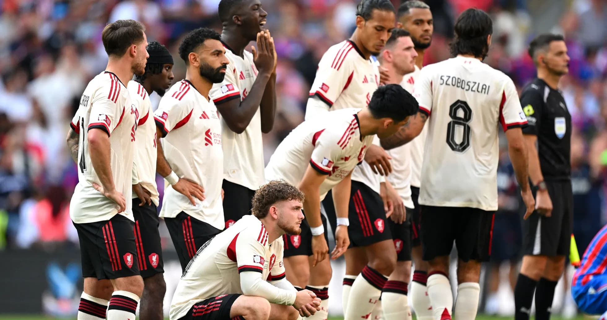 Jugadores de Liverpool esperando un tiro libre en partido