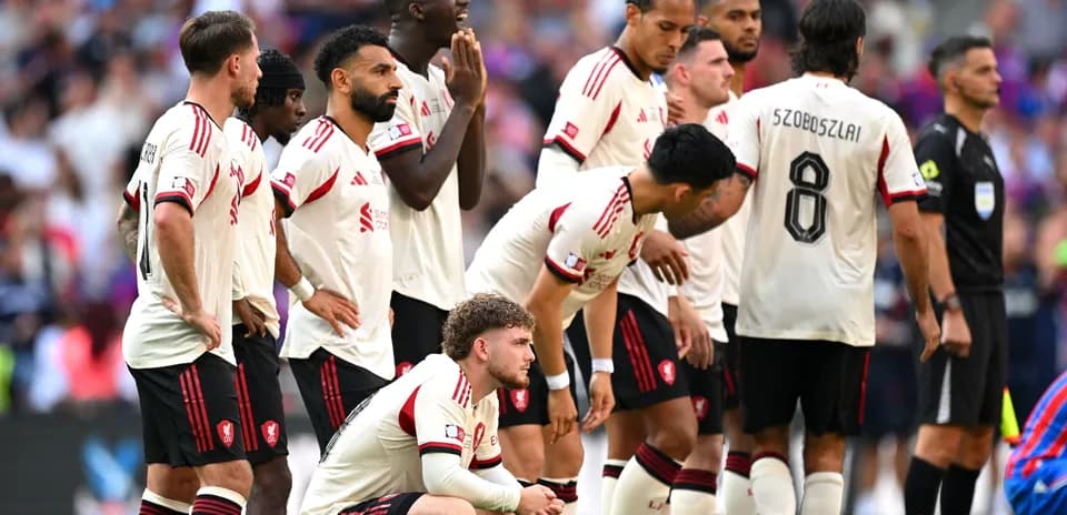 Jugadores de Liverpool esperando un tiro libre en partido