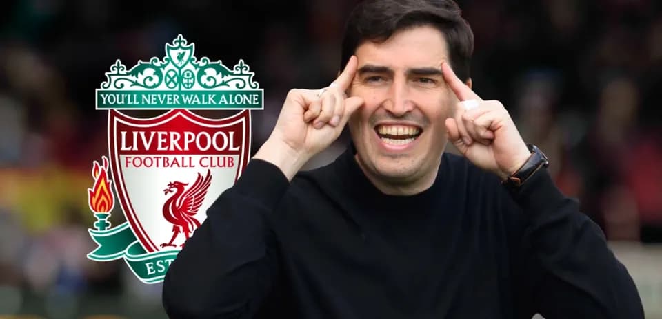 Entrenador sonriente con logo de Liverpool detrás