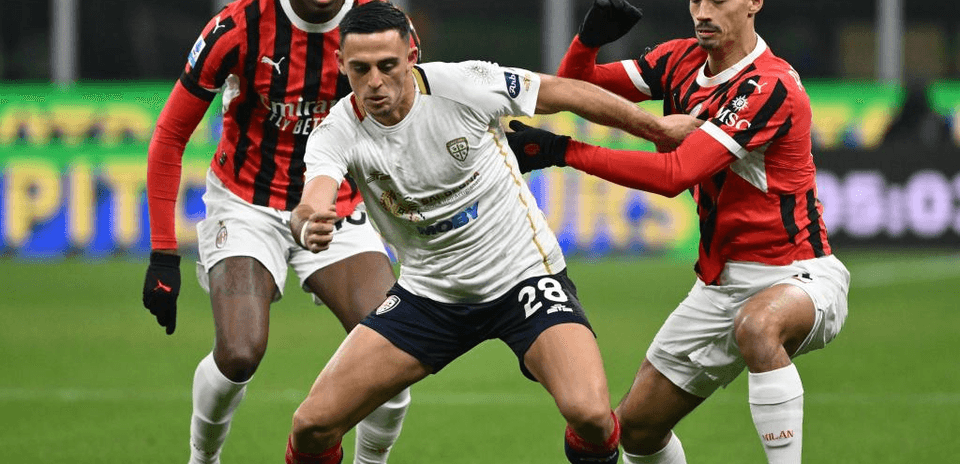 Jugadores de AC Milan y Cagliari luchando por el balón