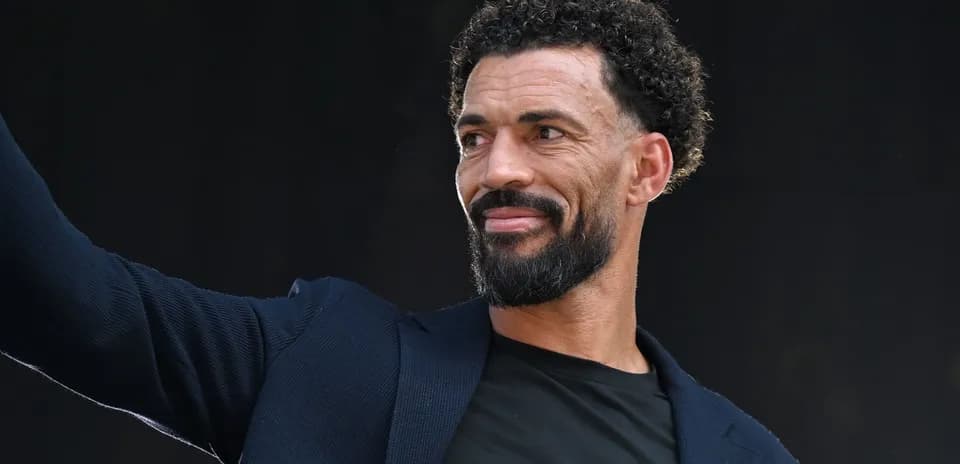 Hombre con barba saludando en un evento
