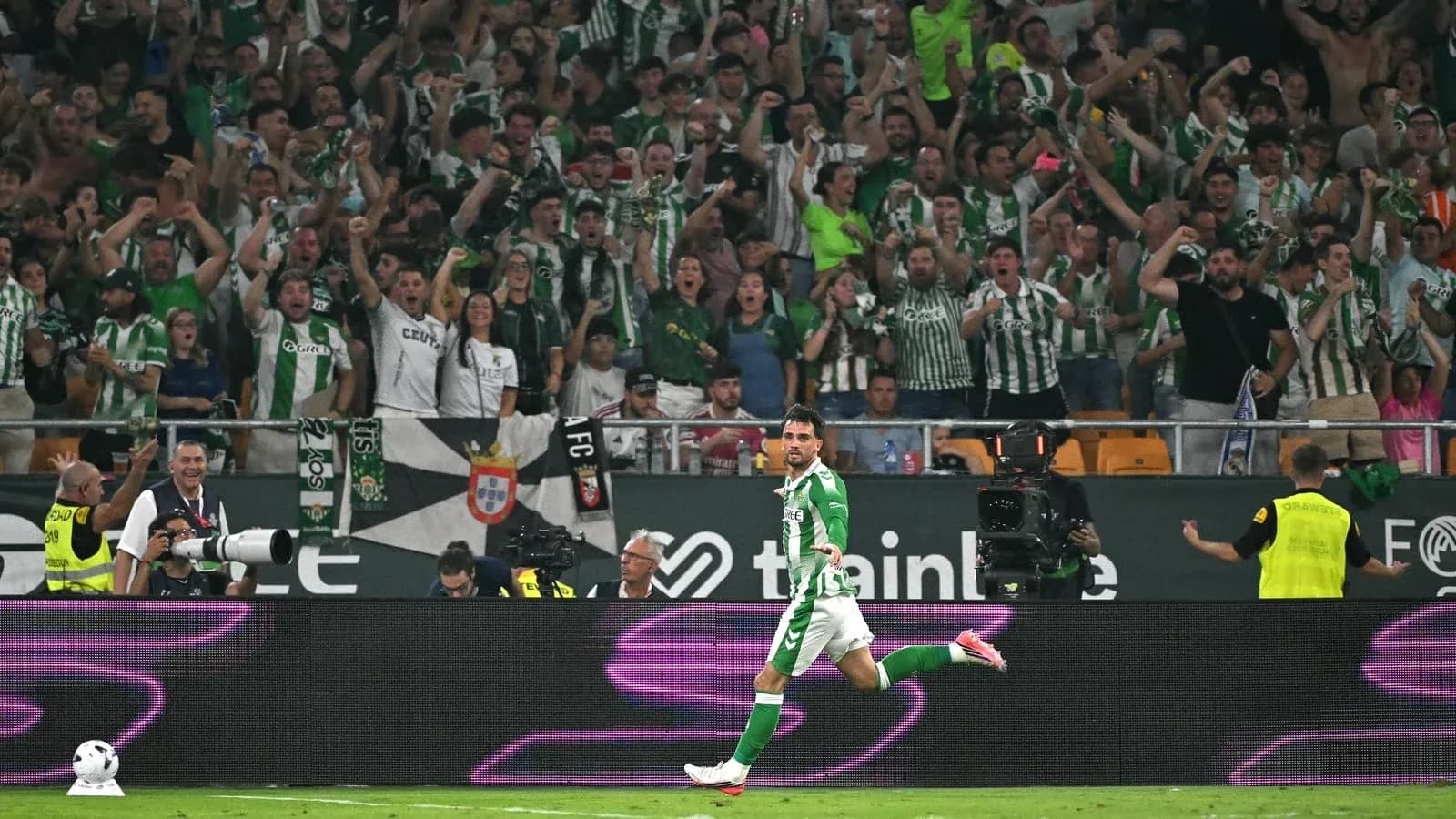 Jugador celebrando un gol con aficionados detrás