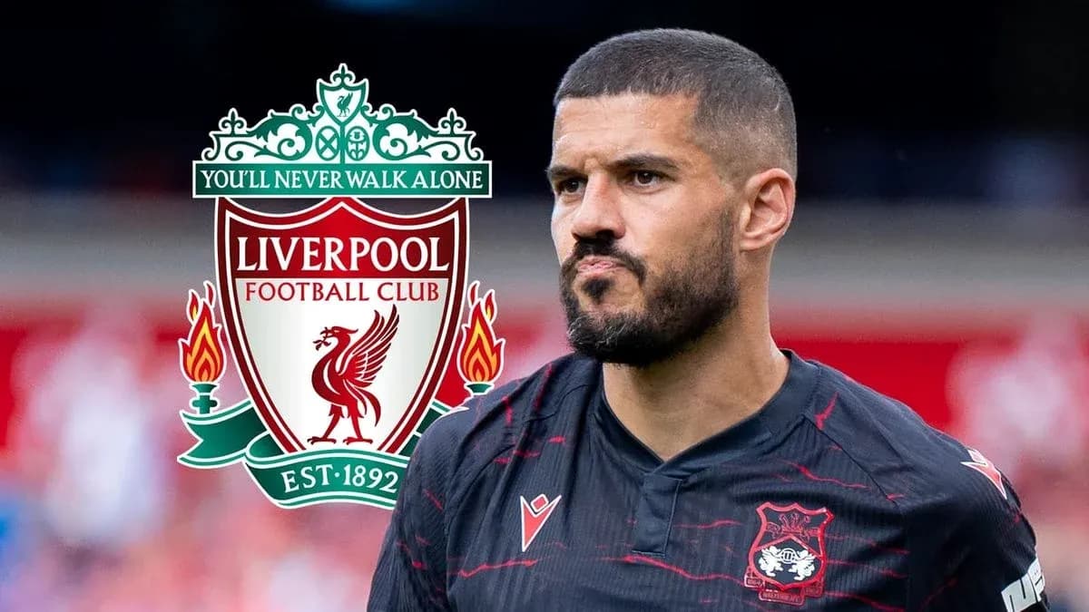 Jugador con camiseta negra junto al escudo de Liverpool