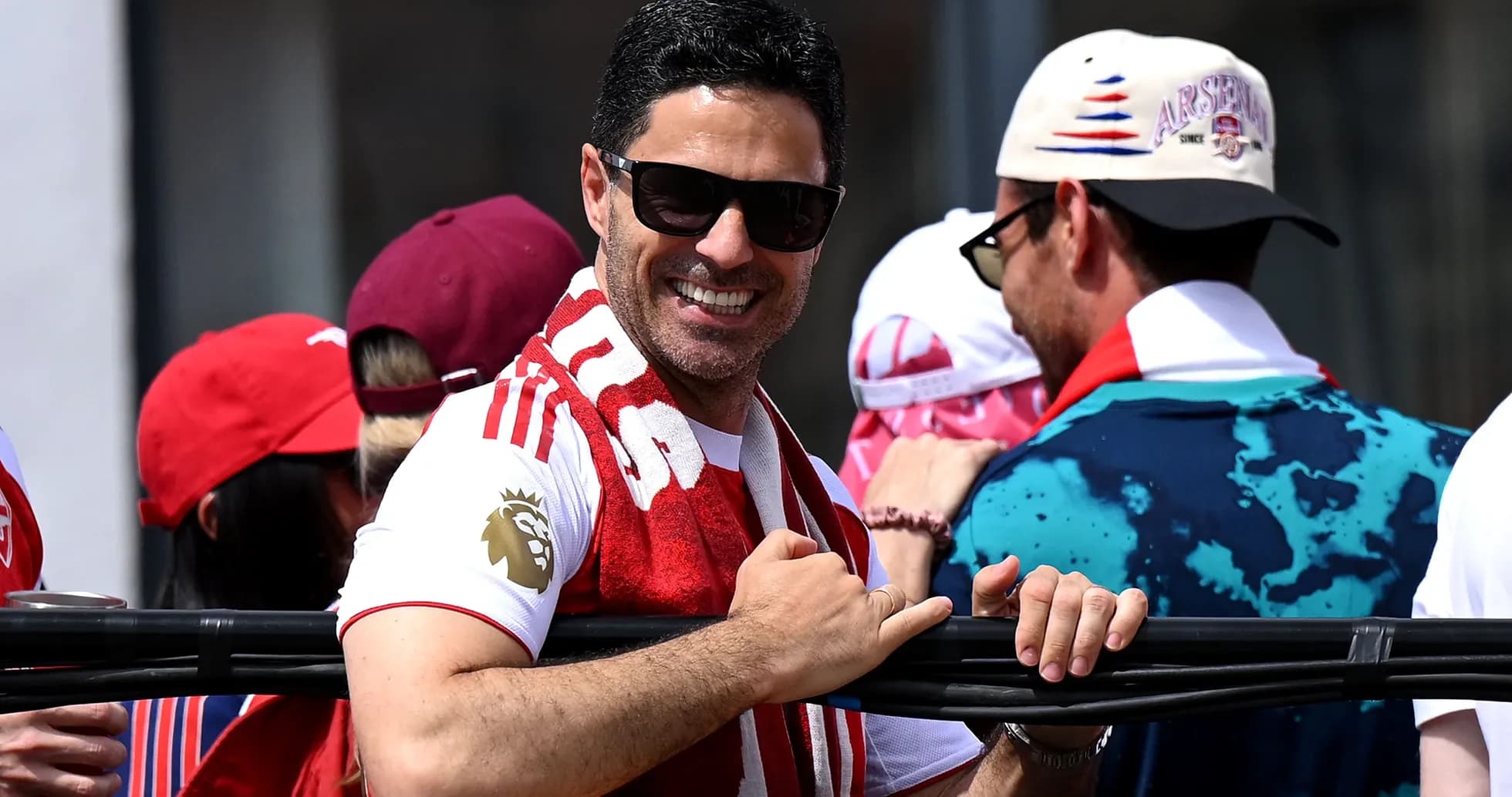 Hombre con gafas de sol y bufanda de Arsenal sonriendo