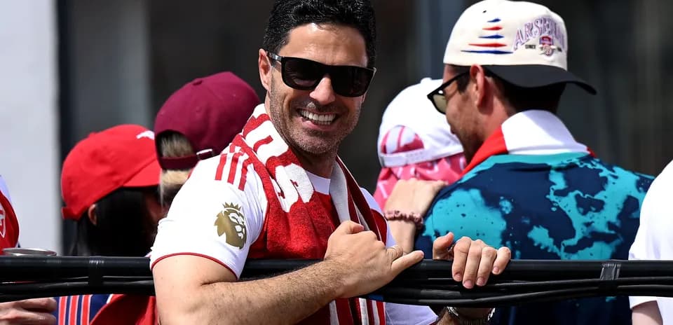 Hombre con gafas de sol y bufanda de Arsenal sonriendo