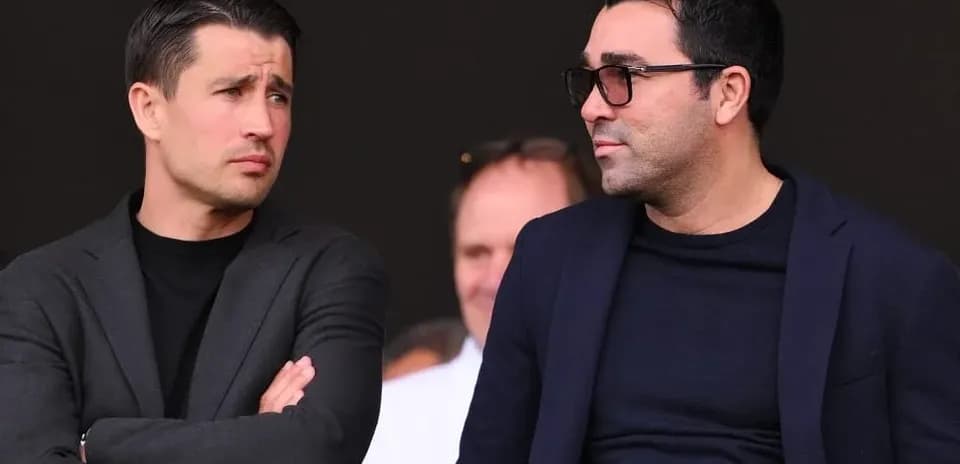 Dos hombres conversando en un evento deportivo