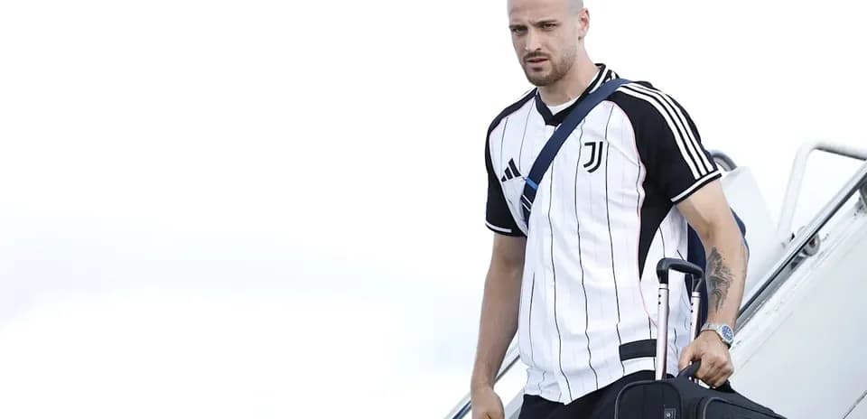 Jugador de Juventus bajando de avión con maleta