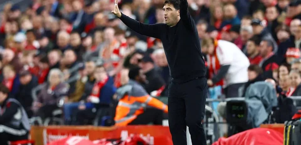 Entrenador gesticulando en la banda durante el partido