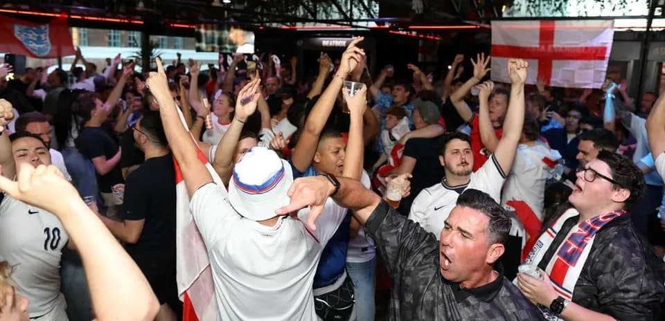 Aficionados animando en un bar durante un partido