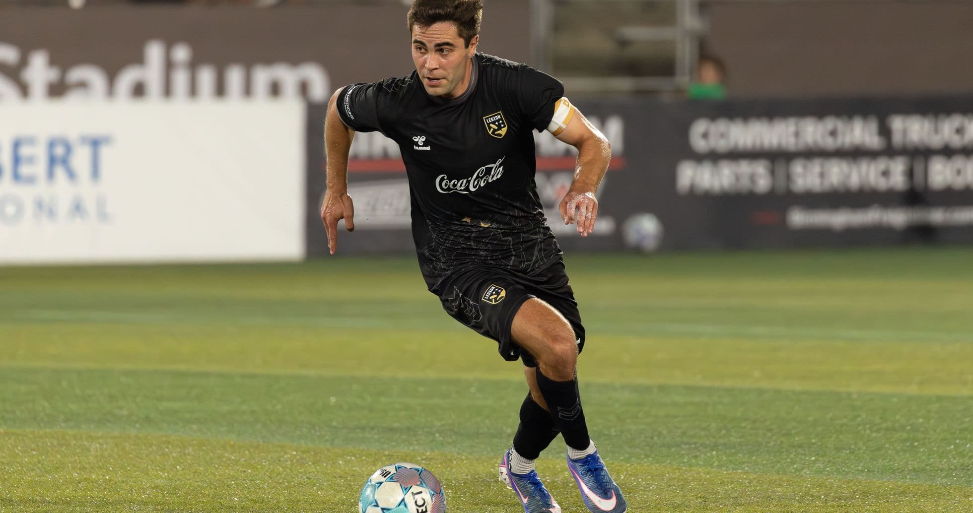 Jugador corriendo con el balón en el campo
