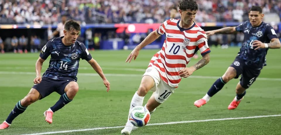 Christian Pulisic dribbling past two defenders during match