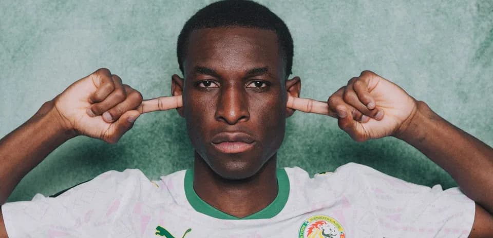 Jugador de fútbol con camiseta de Senegal tapándose los oídos