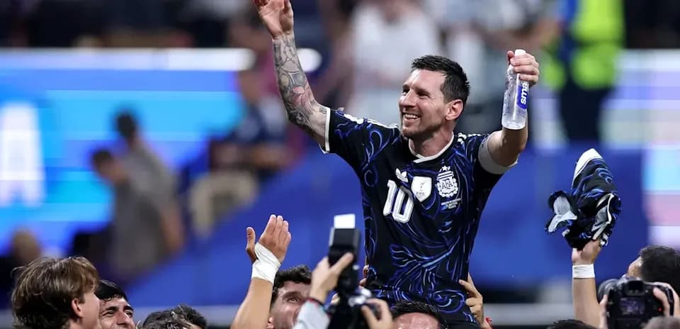 Lionel Messi siendo levantado por compañeros de equipo