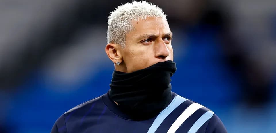 Jugador con abrigo negro en calentamiento previo
